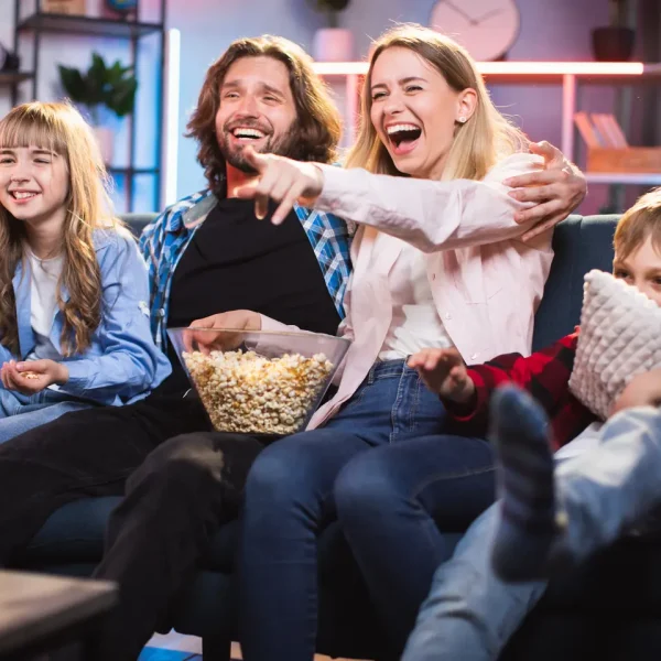 Family enjoying IPTV Smarters Pro subscription on Smart TV – IPTV Smarters Player 2025. Happy family watching movies at home with popcorn using IPTV Smarters 8k Pro subscription on Smart TV – best IPTV Smarters Player 2025. IPTV Subscription, IPTV Smarters Player